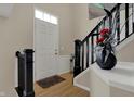 Inviting entryway featuring beautiful hardwood floors, black staircase railing, and classic decor at 2627 Congress St, Carmel, IN 46032