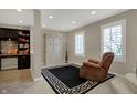 Comfortable sitting area with a recliner, built-in shelving, and natural light from shuttered windows at 2627 Congress St, Carmel, IN 46032