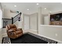 Cozy living room with plush recliner, black and white area rug, and neutral wall colors at 2627 Congress St, Carmel, IN 46032