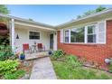 Inviting covered front porch featuring red brick, decorative plants, and an intimate seating area at 2910 S Sheridan Ave, Indianapolis, IN 46203