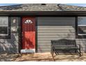 Close-up of a house's red front door and a black bench on the front porch at 2938 Hillside Ave, Indianapolis, IN 46218
