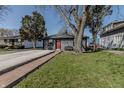Charming grey house features a brick walkway leading to a vibrant red front door at 2938 Hillside Ave, Indianapolis, IN 46218