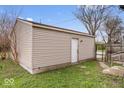 Side view of detached garage showing access door, gravel area, and fenced area at 3070 N Layman Ave, Indianapolis, IN 46218
