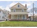 Attractive two-story home featuring a covered front porch and neatly kept lawn at 317 E 37Th St, Indianapolis, IN 46205