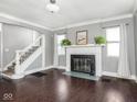 Bright living room with hardwood floors, fireplace, and staircase at 317 E 37Th St, Indianapolis, IN 46205