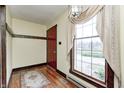 Bright entryway featuring a hardwood floor, a red door, and a sunlit window with elegant drapery at 345 E Main St, Jamestown, IN 46147
