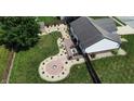 An aerial shot of a beautifully landscaped backyard with patio seating, fire pit, storage shed and lush green lawn at 401 Paddlebrook Dr, Danville, IN 46122