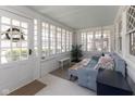 Bright sunroom features many windows, white brick walls, and stylish furnishings at 4030 N Illinois St, Indianapolis, IN 46208