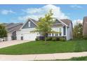 Charming home showing a three-car garage, and manicured lawn surrounded by tidy landscaping at 4196 Parliament Way, Avon, IN 46123