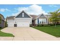 Charming home featuring a three-car garage, manicured lawn, stone accents, and impeccable curb appeal at 4196 Parliament Way, Avon, IN 46123