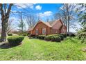Classic brick house with a lush green lawn, neat shrubbery, and mature trees, set on an angle at 4263 W Fox Ridge Ave, Greenwood, IN 46143