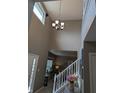 Open entryway with tall ceilings, chandelier, staircase and view into living area at 561 Prince Dr, Greenwood, IN 46142