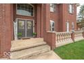 Inviting home entrance with double doors, decorative wreaths, and stylish brick accents at 633 Foxboro Dr, Avon, IN 46123