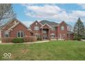 Beautiful red brick home featuring a manicured lawn, symmetrical design, and welcoming front entrance at 633 Foxboro Dr, Avon, IN 46123