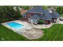 Aerial view of a private backyard oasis featuring a sparkling in-ground pool and patio with lounge chairs at 633 Foxboro Dr, Avon, IN 46123