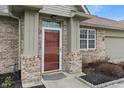 Close up of front door with brick facade and trim and adjacent windows at 6997 Harbour Woods Overlook, Noblesville, IN 46062