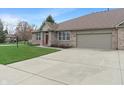A well-kept brick home boasts an attached garage and a neatly paved driveway at 6997 Harbour Woods Overlook, Noblesville, IN 46062