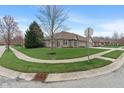 A well-maintained home is seen on a corner lot featuring lush green grass at 6997 Harbour Woods Overlook, Noblesville, IN 46062