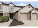 Inviting townhome featuring an attached garage, neutral siding and nicely manicured landscaping at 7208 Long Boat Dr, Indianapolis, IN 46250
