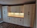 Custom kitchen featuring white cabinets, hardwood floors, and under cabinet lights at 7809 Bryden Dr, Fishers, IN 46038