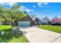 Attractive home with a spacious driveway, attached garage, and lush green lawn at 8807 Wintergreen Way, Indianapolis, IN 46256