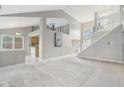 Open-concept living room with high ceilings, carpet flooring, and staircase at 10934 Haig Point Dr, Fishers, IN 46037