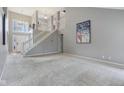 Spacious living room featuring high ceilings, staircase, and carpeted floor at 10934 Haig Point Dr, Fishers, IN 46037