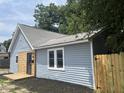 Side view of the home featuring blue vinyl siding, new cedar shake accents, and a fenced yard at 1308 W 18Th St, Indianapolis, IN 46202
