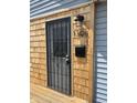 Close up of the front door with cedar accents, a wrought iron screen door, and the house number at 1308 W 18Th St, Indianapolis, IN 46202