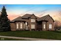 Beautiful brick home with manicured lawn under a colorful sky at 13214 Mink Ln, Carmel, IN 46074