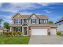 Lovely home featuring a spacious driveway, well-kept lawn, and a mix of brick and siding accents at 2736 Victory Dr, Columbus, IN 47203