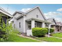 This lovely home boasts mature landscaping, siding, and a covered porch at 422 N Oxford St, Indianapolis, IN 46201