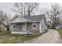 Delightful stone and siding home with a well-maintained gravel driveway and quaint front porch at 4945 Camden St, Indianapolis, IN 46227