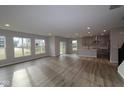 Bright and spacious living room with hardwood floors, large windows, and an open floor plan to the kitchen at 4952 Cinnabar Trl, Brownsburg, IN 46112