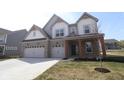Charming two-story home with brick accents, a three-car garage, and a well-manicured lawn at 4960 Cinnabar Trl, Brownsburg, IN 46112