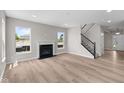 Bright and airy living room featuring large windows, a cozy fireplace, and easy access to the staircase at 4960 Cinnabar Trl, Brownsburg, IN 46112