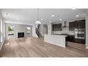 Spacious open concept living room and kitchen boasts hardwood floors, fireplace, and ample natural light at 4960 Cinnabar Trl, Brownsburg, IN 46112