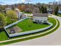Aerial view of a large backyard with a white fence, trampoline, and green grass at 5312 Ripplingbrook Way, Carmel, IN 46033