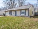 Close-up of a single-story home with gray shutters, green lawn and attached garage at 5512 Straw Hat Dr, Indianapolis, IN 46237