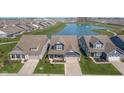 Beautiful aerial view of craftsman-style homes, well-manicured lawns, and serene pond with fountain feature at 622 Ehrlich Ln, Westfield, IN 46074