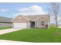 Charming single-Gathering home with a manicured lawn and two-car attached garage at 6467 W Whispering N Way, Greenfield, IN 46140