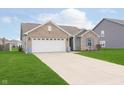 Inviting two-car garage home with a well-maintained lawn and concrete driveway at 6467 W Whispering N Way, Greenfield, IN 46140