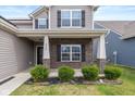 Inviting front porch with brick accents and manicured landscaping adds curb appeal at 6535 Heben Ct, Indianapolis, IN 46113