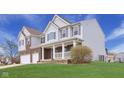 Charming home featuring a covered porch, brick accents, and well-manicured lawn at 7048 Millet Ln, Avon, IN 46123