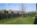 Spacious backyard featuring grass, partial privacy fencing, and plenty of room for outdoor activities at 8142 Bentley Farms Dr, Indianapolis, IN 46259