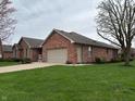 Charming red brick home with a well-manicured lawn and an attached two-car garage at 1066 Woodridge, Brownsburg, IN 46112