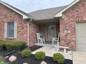 Quaint front porch with rocking chairs, a bench, and attractive landscaping at 1066 Woodridge, Brownsburg, IN 46112