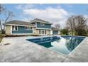 A refreshing in-ground pool sits next to a blue two story house at 1107 Leisure Ln, Greenwood, IN 46142