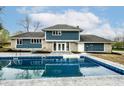 A refreshing in-ground pool sits next to a blue two story house at 1107 Leisure Ln, Greenwood, IN 46142
