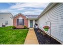 Charming home featuring a brick accent, a welcoming walkway, and a beautifully landscaped front yard at 12319 Wolf Run Rd, Noblesville, IN 46060